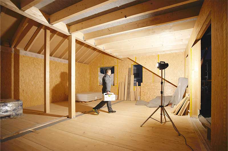 Būvniecības prožektors izgaismo tumšu telpu bez logiem